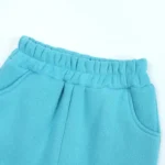 Detail of custom baby joggers waistband and pocket, featuring high-recovery elastic, durable arched side pockets, and precision topstitching. Premium cotton fleece infant activewear from a professional clothing manufacturer.