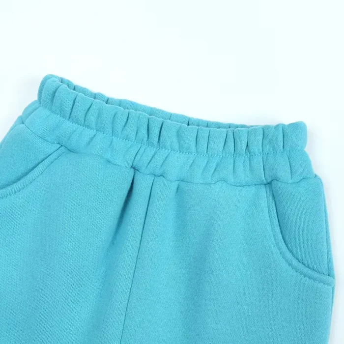 Detail of custom baby joggers waistband and pocket, featuring high-recovery elastic, durable arched side pockets, and precision topstitching. Premium cotton fleece infant activewear from a professional clothing manufacturer.