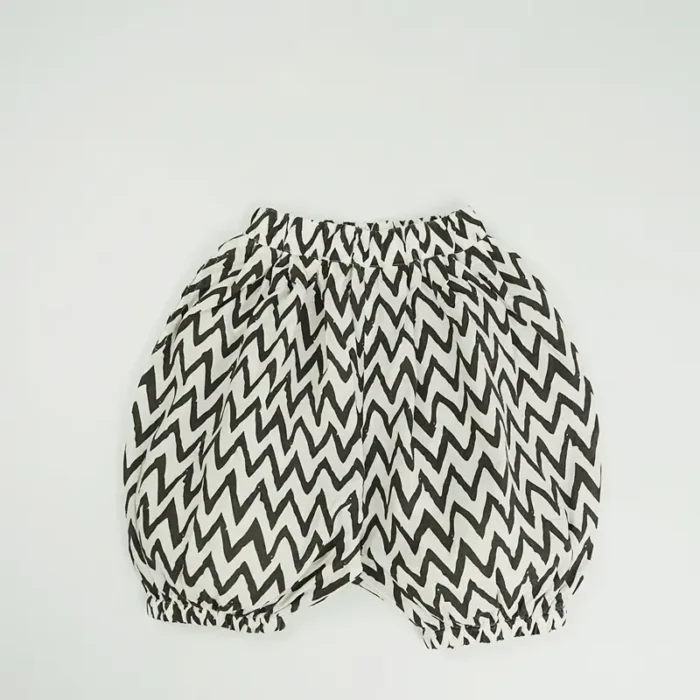 Custom black and white chevron baby bloomers, featuring a trendy zigzag print, voluminous bubble silhouette, and comfortable elastic waistband. High-quality infant diaper cover shorts from a professional OEM/ODM clothing manufacturer.