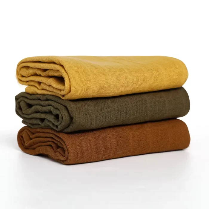 A stack of solid-colored baby washcloths in mustard yellow, olive green, and brown, from a China baby washcloths manufacturer.