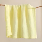 Light yellow cotton muslin baby washcloth with crinkle texture, manufactured by a China baby washcloths factory.