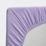 Fitted corner detail of a purple muslin crib sheet from a professional crib sheets factory in China.