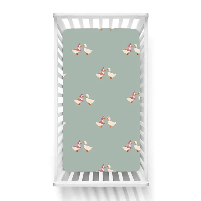 Cute duckling pattern crib sheets in sage green on a baby bed, produced by a crib sheets manufacturer in China.